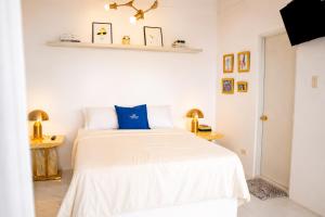 a bedroom with a white bed with blue pillows at Bintana Sa Paraiso in Mambajao