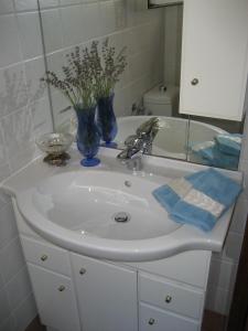 a bathroom sink with a vase of flowers on it at Valun Seaside Apartments in Valun