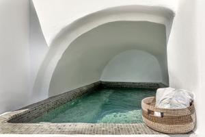 a pool of water with a basket in a tunnel at Just Blue in Oia
