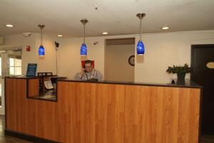 a man talking on a cell phone behind a counter at Expo Inn in Tulsa