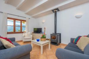 a living room with two blue couches and a stove at Son Bou in Sóller
