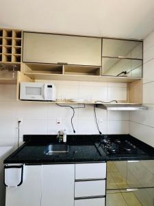 a kitchen with a sink and a microwave at Cavalheris House - Rota das Vinícolas in Espirito Santo Do Pinhal +1 photo
