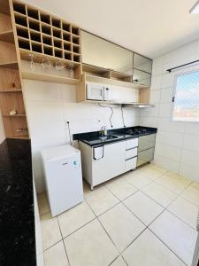 a small kitchen with a white refrigerator and cabinets at Cavalheris House - Rota das Vinícolas in Espirito Santo Do Pinhal