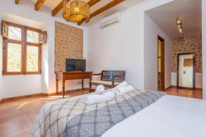 a bedroom with a large bed and a desk at Can Raia in Sóller