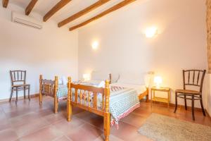 a bedroom with a bed and two chairs in it at Can Raia in Sóller