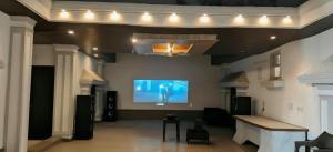 a large living room with a flat screen tv on the wall at Party Place with pool in Ballabgarh