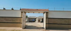 an open door to a building with a roof at Party Place with pool in Ballabgarh