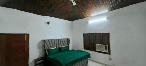 a room with a green chair in a room at Party Place with pool in Ballabgarh