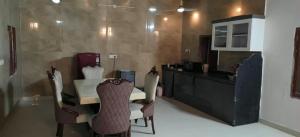 a kitchen with a table and chairs and a counter at Party Place with pool in Ballabgarh +8 photos