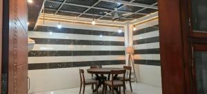 a dining room with a black and white striped wall at Party Place with pool in Ballabgarh