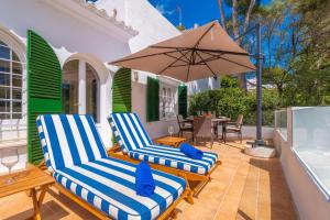 two chairs and an umbrella on a patio at Cala Dor 14 in Cala d´Or