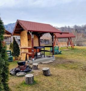 a pavilion with a playground in a yard at Casa Ionela nr 13- Complex de pensiuni si Casute la Munte in Ceahlău