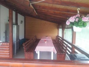 a dining room with a table and flowers in a room at Casa Ionela nr 13- Complex de pensiuni si Casute la Munte in Ceahlău