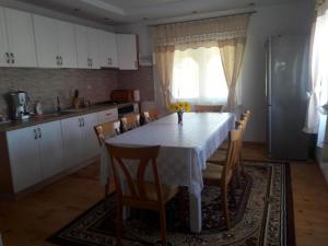 a kitchen with a table and chairs and a kitchen with a refrigerator at Casa Ionela nr 13- Complex de pensiuni si Casute la Munte in Ceahlău +8 photos