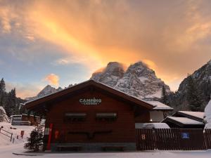 a rainbow over a ski lodge with a mountain at Camping Cadore in Selva di Cadore