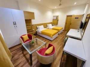 a hotel room with a bed and two chairs at FlexiBay Boys Hostel Noida in Noida