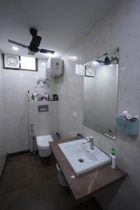 a bathroom with a sink and a toilet and a mirror at FlexiBay Boys Hostel Noida in Noida