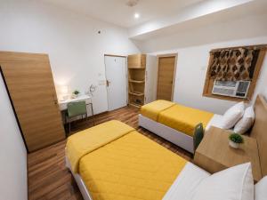 a hotel room with two beds and a desk and a table at FlexiBay Boys Hostel Noida in Noida