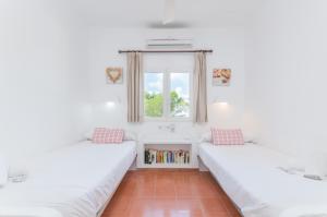two beds in a room with a window at Cala Dor 14 in Cala d´Or