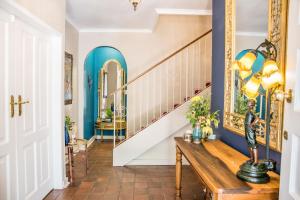un pasillo con un banco de madera y escaleras con paredes azules en 5th Avenue Gooseberry Guest House, en Johannesburgo 165 fotos más
