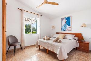 a bedroom with a bed and a chair and a window at Villa Ca Mestre Rafel by Escape Home in Santo Tomás +51 photos