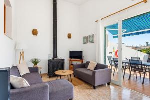 a living room with two couches and a table and a tv at Villa Ca Mestre Rafel by Escape Home in Santo Tomás