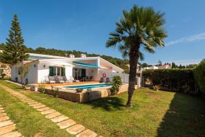 a house with a palm tree and a swimming pool at Villa Ca Mestre Rafel by Escape Home in Santo Tomás