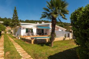 a house with a palm tree and a swimming pool at Villa Ca Mestre Rafel by Escape Home in Santo Tomás