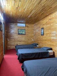 a row of beds in a room with wooden walls at Elephant homestay in Sapa +52 photos