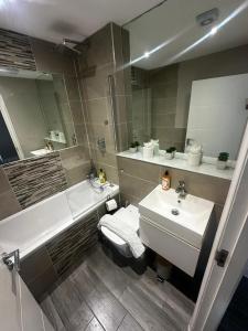 a bathroom with a sink and a toilet and a tub and a sink at Stunning Sea View 2BR Flat Sleeps 5 Walk to Beach - Big Savings for Extended Stays - by Nestora Stays Ltd in Brighton & Hove +15 photos
