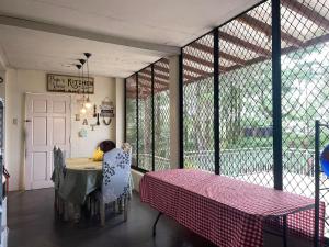 a person sitting at a table in a room at Pine's View Casa Isabel Villa Staycation - Marilog, Davao City in Kayagan