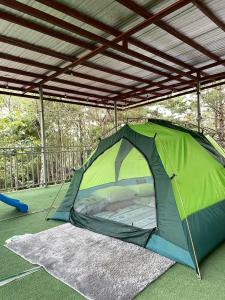 a green tent on the ground under a roof at Pine's View Casa Isabel Villa Staycation - Marilog, Davao City in Kayagan +6 photos