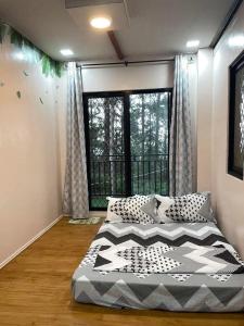 a bedroom with two beds and a large window at Pine's View Casa Isabel Villa Staycation - Marilog, Davao City in Kayagan