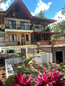 a large house with pink flowers in front of it at Pine's View Casa Isabel Villa Staycation - Marilog, Davao City in Kayagan