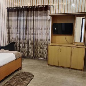a bedroom with a bed and a flat screen tv at Snow Valley in Dhanaulti