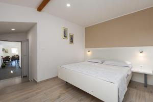 a white bedroom with a bed and a table at House Prenc in Pazin +27 photos