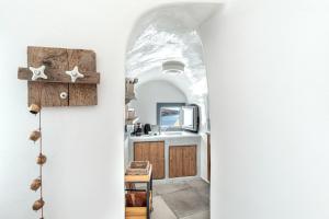 a hallway leading to a kitchen with an archway at Just Blue in Oia