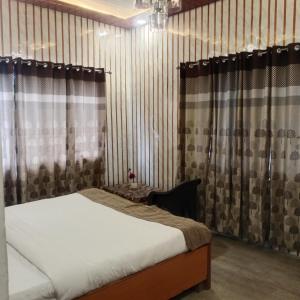 a bedroom with a bed and curtains in a room at Snow Valley in Dhanaulti