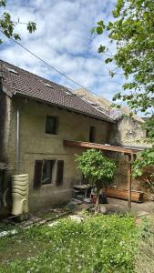 a house with a porch and a tree in front of it at Haus in Roth an der Our in Roth