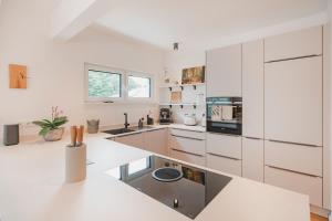 a white kitchen with white cabinets and appliances at Ferienbungalow Ochsenkopf in Gefrees