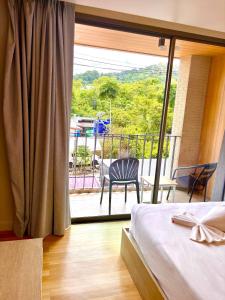 a bedroom with a bed and a view of a balcony at Adventure Condo Aonang in Ao Nang Beach