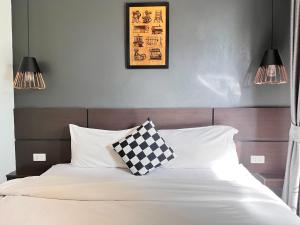 a bedroom with a bed with a checkered pillow on it at The CHESS Samui in Chaweng