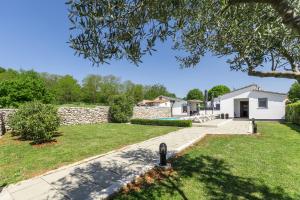 a yard with a stone wall and a house at House Prenc in Pazin