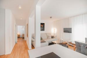 a white living room with a couch and a table at Ferienbungalow Ochsenkopf in Gefrees