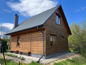 a log cabin with a gambrel roof at Domek Twórczy Kąt in Święta Katarzyna
