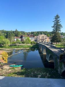 a bridge over a river with a boat in the water at Hostellerie Les Griffons in Brantome en Perigord
