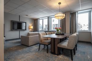 a dining room with a table and chairs and a tv at Thon Hotel Andrikken in Andenes