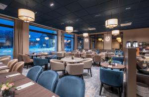 a restaurant with tables and chairs and windows at Thon Hotel Andrikken in Andenes