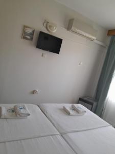a bedroom with a bed and a tv on the wall at Çidihan HOTEL in Kuşadası