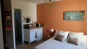 a small room with a bed and a microwave at Studio La passagère in Plouvorn